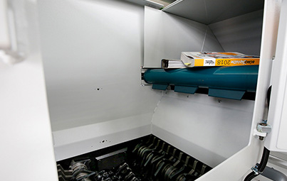 Telefonbuch auf Förderband im Schredder